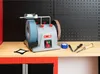 A wet/dry sharpening machine is set up on a workbench with tools and accessories. Anteprima dell’immagine prodotto