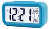 A blue digital alarm clock displaying the time, date, and temperature. Náhled obrázku produktu