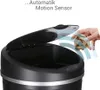 A hand is about to drop crumpled paper into an open automatic trash can. The trash can lid is open and motion waves are depicted around the hand and trash can. Produktbild-Vorschau