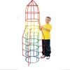 A young boy stands next to a tall, colorful rocket-shaped building toy made of interconnected tubes. Podgląd zdjęcia produktu