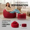 A woman is sitting on a large red beanbag chair in a living room setting, with a smaller red ottoman next to her. The image also shows a smaller red beanbag and ottoman with a plus sign, suggesting a bundle or expansion option. Voir les images du produit