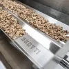 A close-up view of wood chips in a metal tray, with the brand name 'SKOTTI' engraved on the tray. Produktbild-Vorschau