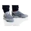 A pair of Nike Air Vapormax 2021 FK SE shoes worn by a person. Voir les images du produit