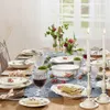 A beautifully set dining table with floral arrangements and tableware. Náhled obrázku produktu