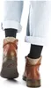 A close-up view of the back of a person's legs wearing brown ankle boots and light blue cuffed jeans. Produktbild-Vorschau