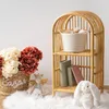 A rattan bookshelf with decorative items in a nursery or child's room. Náhľad obrázku produktu