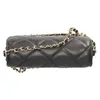 A black quilted crossbody bag with a gold chain strap, shown from a side angle against a white background. Produktbild-Vorschau
