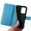 A hand holding a blue flip phone case with a floral and butterfly design. Produktbild-Vorschau