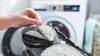 A hand is shown attaching a cleaning pad to a robotic vacuum cleaner. Produktbild-Vorschau