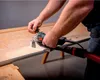 A person is using a power tool to work on a wooden surface. Anteprima dell’immagine prodotto