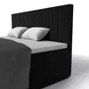 A black box spring bed with a padded headboard and two white pillows, partially covered by a dark gray blanket. Voir les images du produit