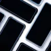 Several black smartphone screens with clear cases are arranged diagonally on a white background. Anteprima dell’immagine prodotto