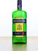 A green glass bottle of Becherovka herbal liqueur stands on a wooden surface against a white background. Produktbild-Vorschau