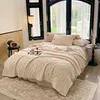 A cozy bedroom scene with a bed covered in a thick, textured beige blanket, pillows, and a tray with a drink. Anteprima dell’immagine prodotto