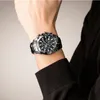 A person wearing a black long-sleeved shirt and a watch on their wrist. Anteprima dell’immagine prodotto