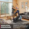 A woman is exercising on an elliptical machine in a modern living room with a dog lying on the floor. Produktbild-Vorschau