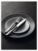 A close-up shot of a dessert knife and fork set on two plates, arranged on a dark, textured surface. Produktbild-Vorschau