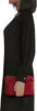 A woman in a black dress holds a red purse. Produktbild-Vorschau