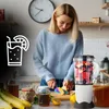 A woman is preparing a smoothie in a kitchen. Produktbild-Vorschau
