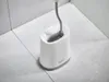 A toilet brush and holder set on a tiled floor. Podgląd zdjęcia produktu