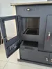 A close-up, angled view of a wood-burning stove with its door open, revealing the interior and a drawer. Produktbild-Vorschau