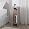 A modern bedside table next to a bed, with a phone charging on top and books on the shelf. Podgląd zdjęcia produktu