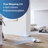 A person walks past a robot vacuum cleaner in a modern living room. Voir les images du produit