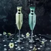 Two Bamix immersion blenders are displayed on a dark, textured surface with scattered white confetti and white flowers. Náhled obrázku produktu