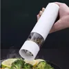 A hand holding a white electric pepper grinder over a plate of food. Podgląd zdjęcia produktu
