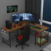 A gaming setup with a corner desk, multiple monitors, a gaming chair, and accessories. Anteprima dell’immagine prodotto