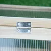 A close-up view of a metal hinge attached to a wooden frame, with a transparent corrugated material visible below. Voir les images du produit