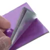 A hand is shown peeling back a layer of purple foil from a stack of similar foil sheets. Produktbild-Vorschau