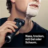 A man is shaving his face with an electric razor, with shaving foam on one side of his face. Náhled obrázku produktu