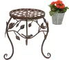 A metal plant stand with a decorative design and a potted plant with orange flowers. Produktbild-Vorschau