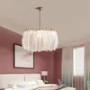 A bedroom scene with a feather chandelier hanging above a bed. Podgląd zdjęcia produktu