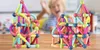 A child is blurred in the background, smiling and looking at magnetic building blocks. Náhled obrázku produktu