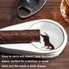A cigar and cigar cutter on a wooden surface, with a cigar ashtray in the foreground. Produktbild-Vorschau