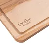 A close-up view of a wooden cutting board with a carved logo. Produktbild-Vorschau