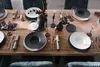 A beautifully set dining table with plates, cutlery, and glasses, ready for a meal. Produktbild-Vorschau