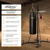 A boxing bag stand with a punching bag and speed ball in a room with a brick wall. Produktbild-Vorschau