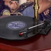 A person wearing headphones is lying down with their eyes closed, listening to music from a record player. Produktbild-Vorschau