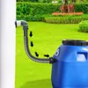 A rain barrel connected to a downspout with a flexible hose, set in a garden. Produktbild-Vorschau