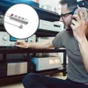 A man wearing headphones is adjusting audio equipment while a power strip is shown in a circular inset. Produktbild-Vorschau