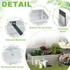 A raised garden bed filled with plants, surrounded by gardening tools and decorative elements. Voir les images du produit