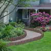 A garden path bordered by wooden-look edging, leading to a house with hydrangeas. Náhled obrázku produktu
