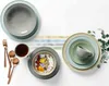 A flat lay of a breakfast setting with plates, bowls, cutlery, and a cup of coffee. Produktbild-Vorschau