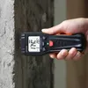 A hand holding a digital moisture meter against a concrete wall. Produktbild-Vorschau