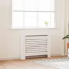 A white radiator cover is placed in front of a window with white blinds. Podgląd zdjęcia produktu