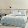 A neatly made bed with light blue bedding and white accent pillows and blankets. Produktbild-Vorschau