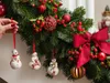 A hand is shown decorating a Christmas wreath with ornaments. Produktbild-Vorschau